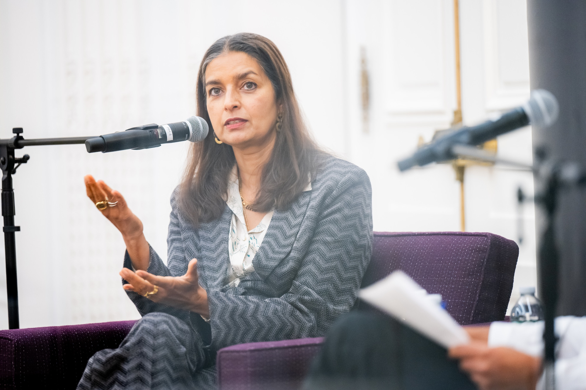 Jhumpa Lahiri talking and gesturing with her hands.